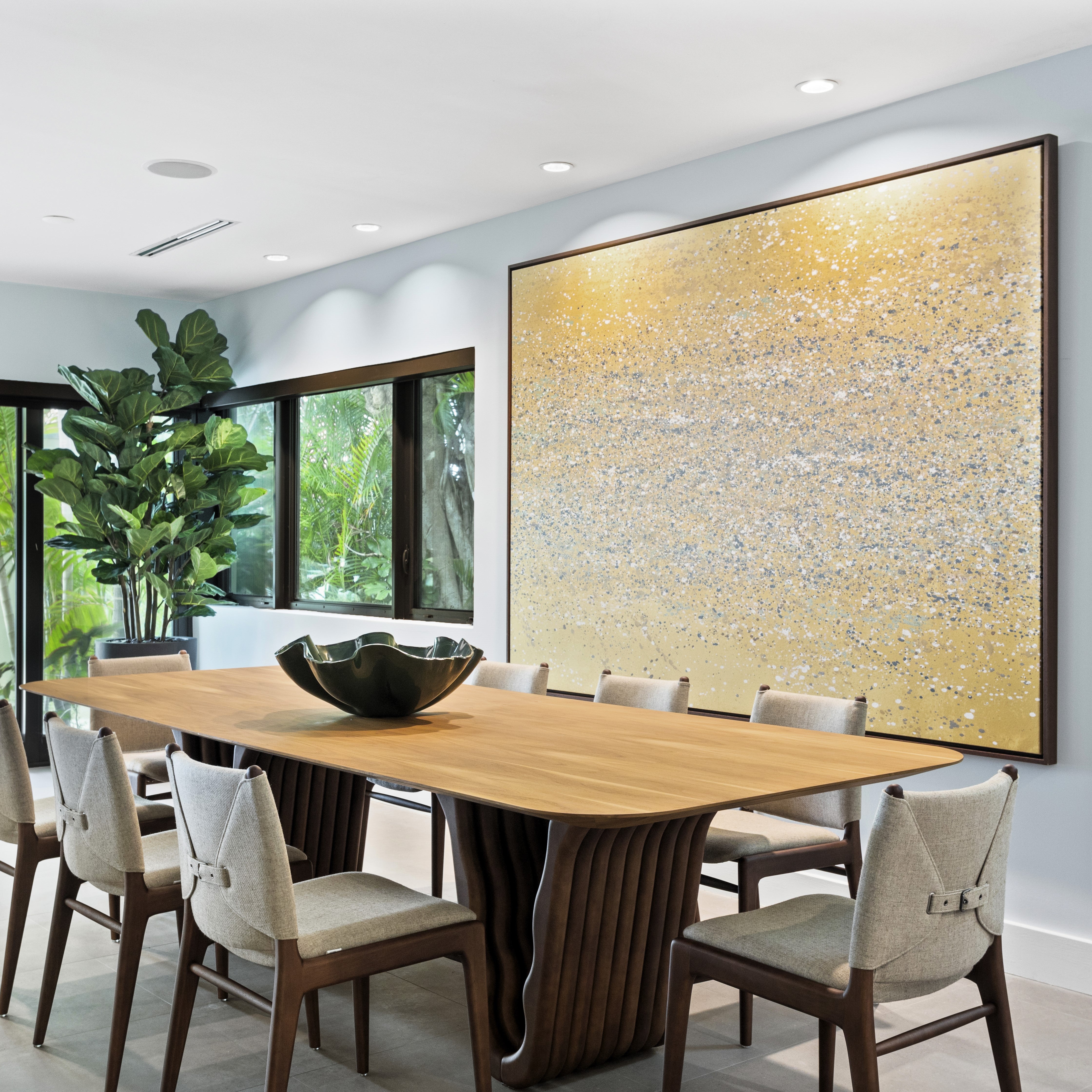 Modern dining room with wooden table and chairs, large abstract painting on wall.