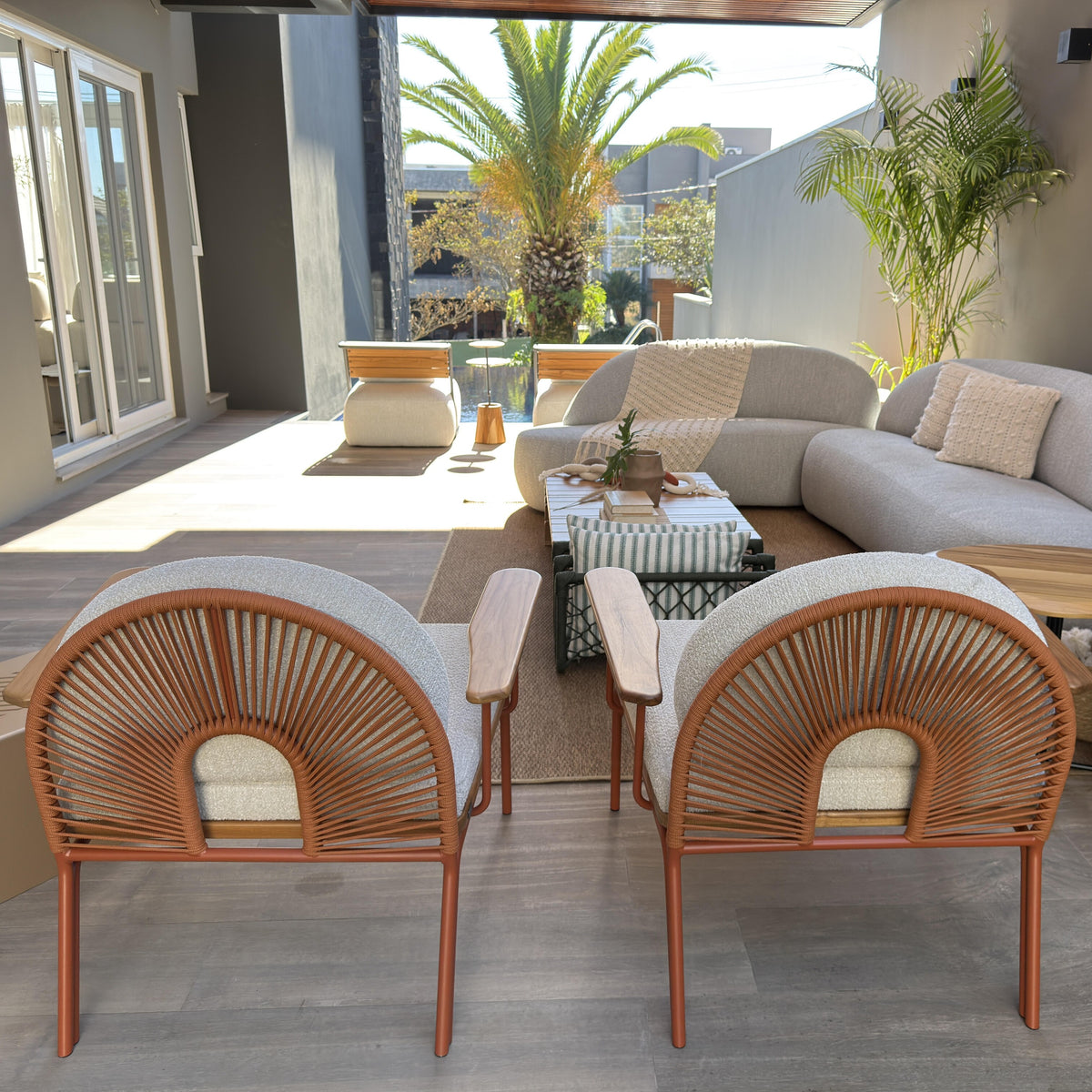 Outdoor patio with beige sofa, wicker chairs, and a small table.
