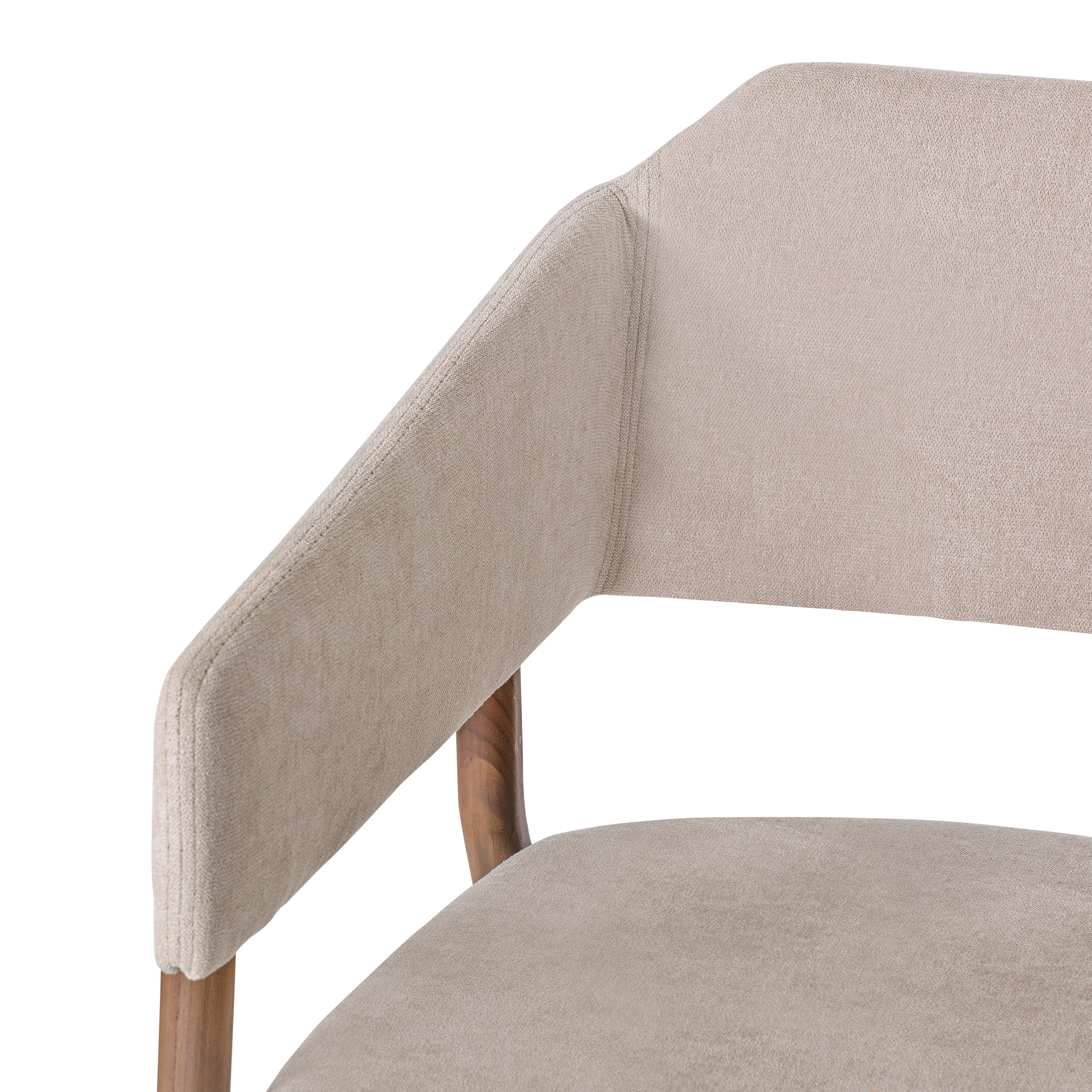 Close-up of a beige upholstered chair with wooden legs on a white background