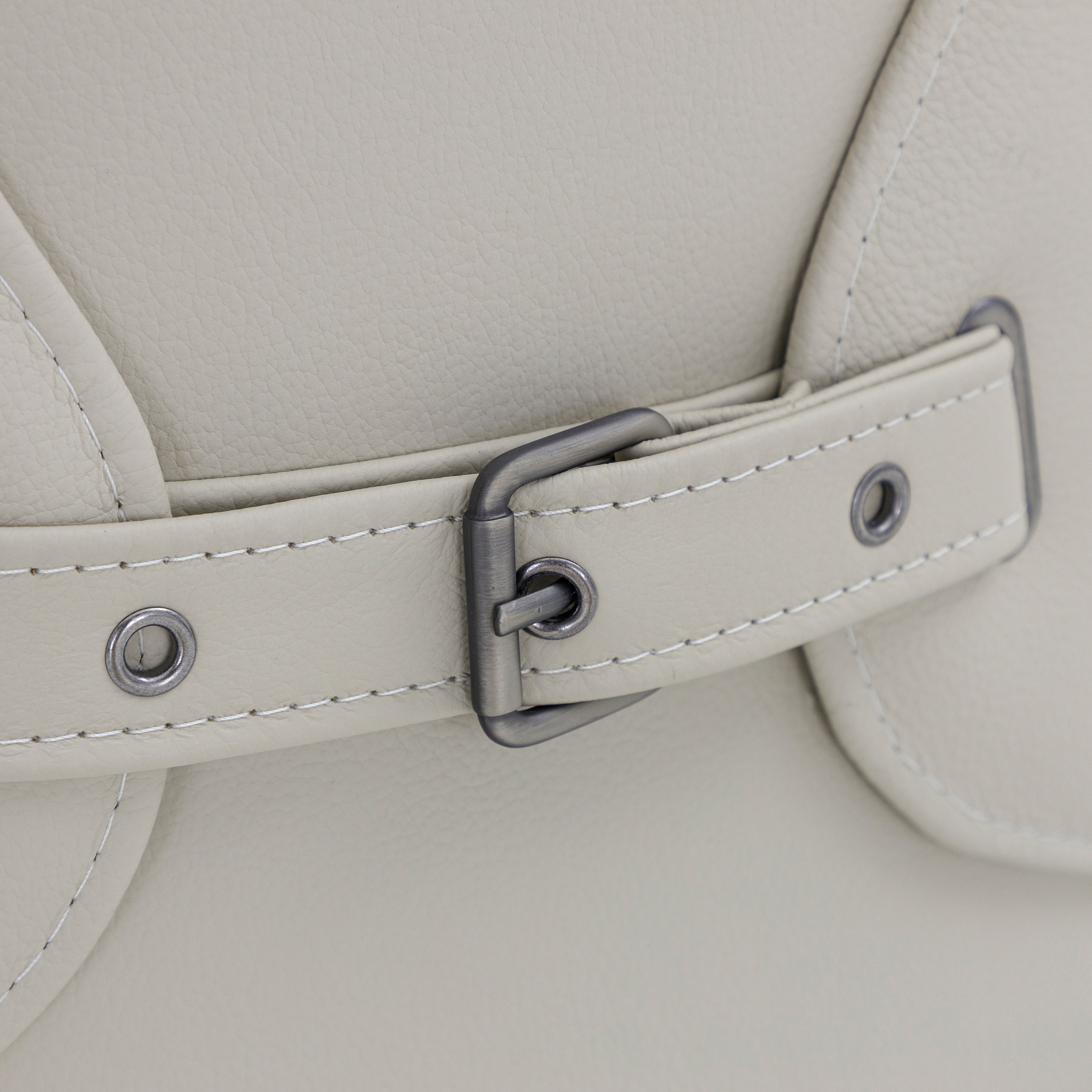 Close-up of a light gray leather bag with a strap and buckle detail.