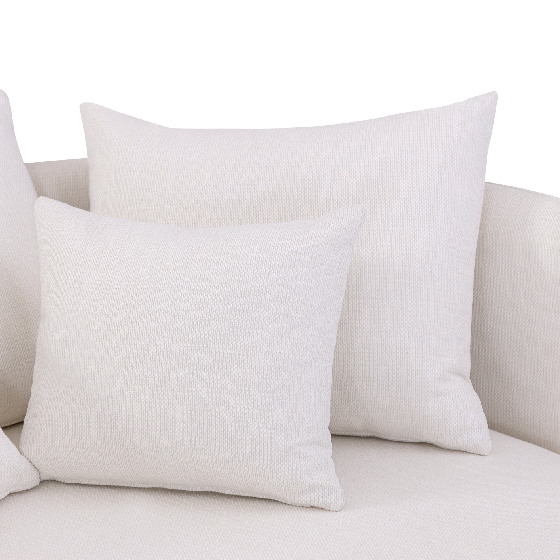White textured pillows on a light gray sofa against a white background